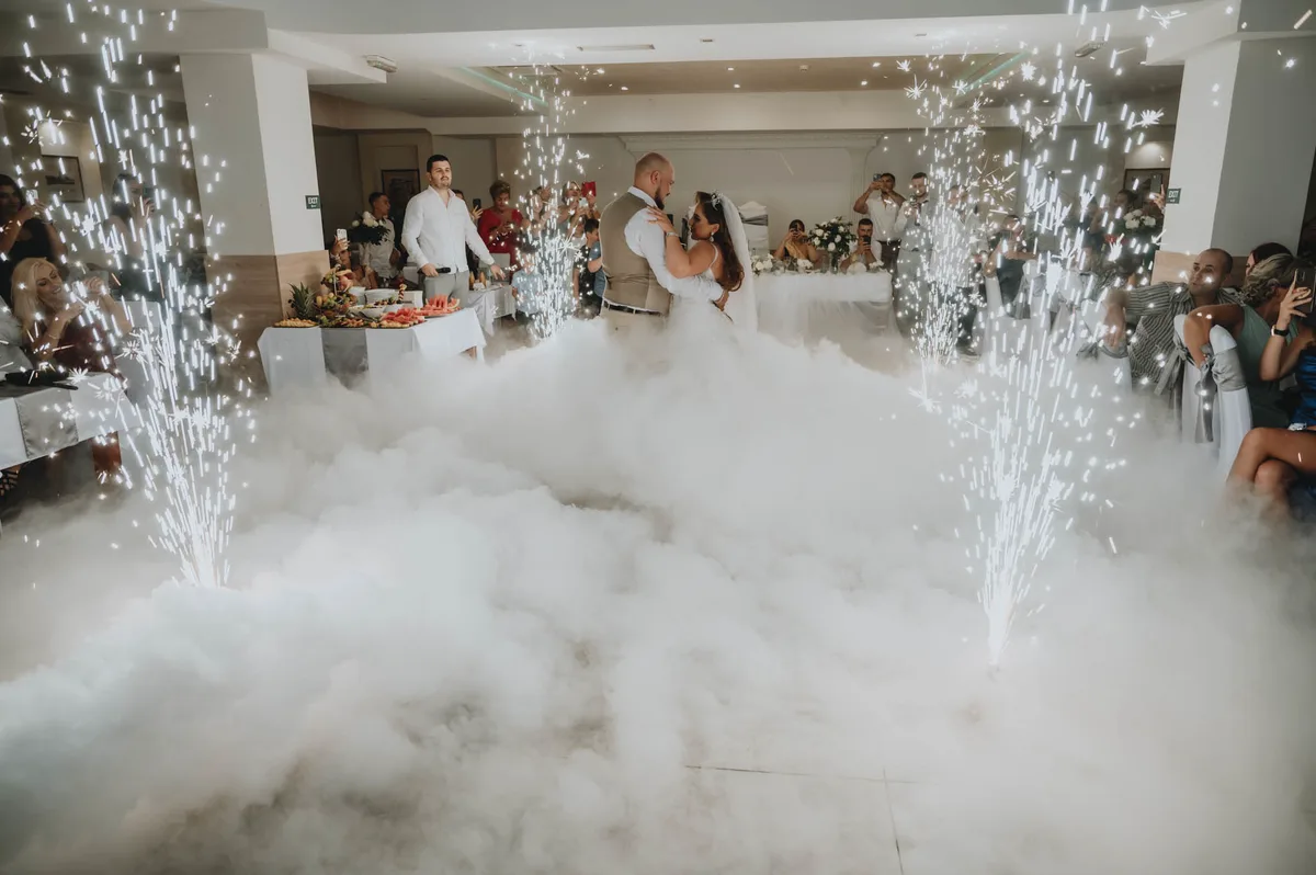 The dance floor covered in low fog, with sparkler fountains around the couple