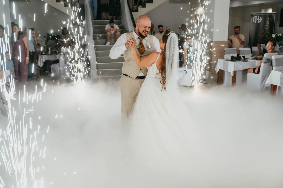 The newlyweds laughing during their first dance among sparklers
